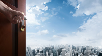 hand opens open door to city