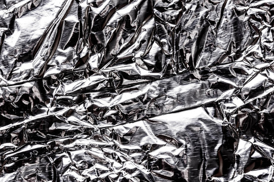 Crumpled wrinkled silver foil texture.