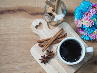 black coffee cup and cinnamon with spicy herb on wooden tray