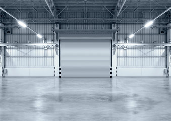 Roller door or roller shutter inside factory, warehouse or industrial building. Modern interior design with polished concrete floor and empty space for product display or industry background.