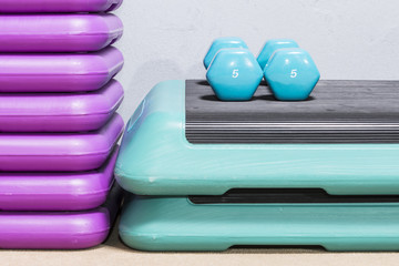 Green dumbbells on a step deck. Five kilograms.

