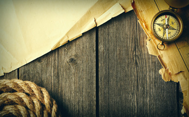 Antique compass and rope over old map