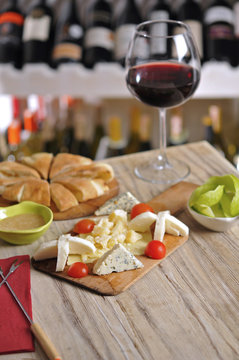 Cheese plate and red wine on wooden table