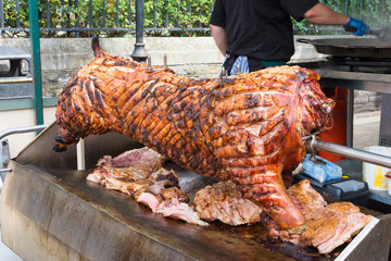 Spit roasting pork with succulent crackling ready for carving.