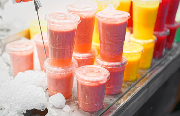 Side view of a stack of glasses of fruit smoothie in a market in Barcelona (selective focus)