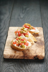 homemade crostini with tomato, mozzarella and olives