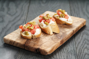 homemade crostini with tomato, mozzarella and olives