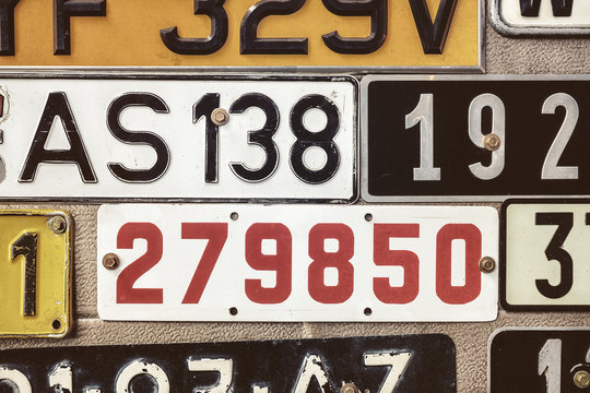Old number plates on a metal garage door