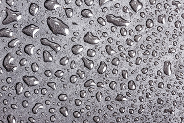 Water bubbles on black surface texture.