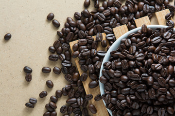 Coffee beans with a plate on a wooden floor.