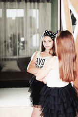 beautiful elegant teen girl looking in the mirror