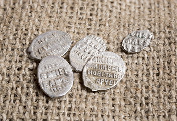 Some silver Russian pre-Empire coins on a burlap canvas