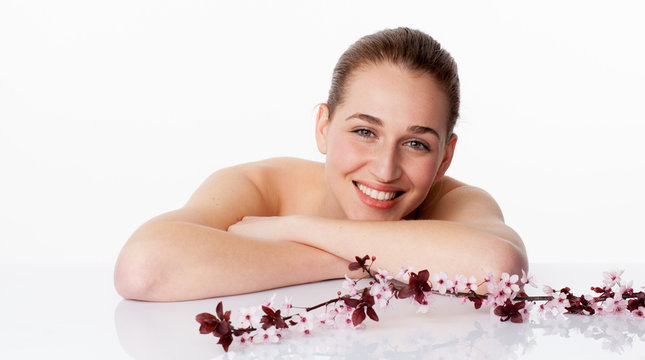 Spring Spa Concept - Thrilled Beautiful Young Woman Leaning Her Face Down On White Glass For Fresh Natural Skincare On White Background,studio Shot