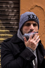Handsome guy smoking. / Handsome boy posing on the street while smoking a cigarette. 