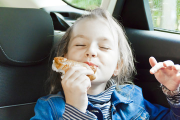 Eating cute girl sitting inside car