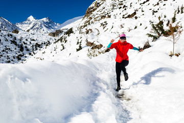 Fototapeta na wymiar Woman running in winter mountains