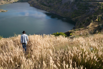 Девушка идущая к озеру в горах