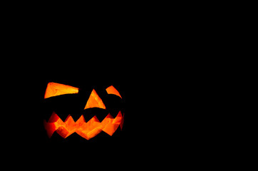 Jack O Lantern halloween pumpkin on black background - holidays concept