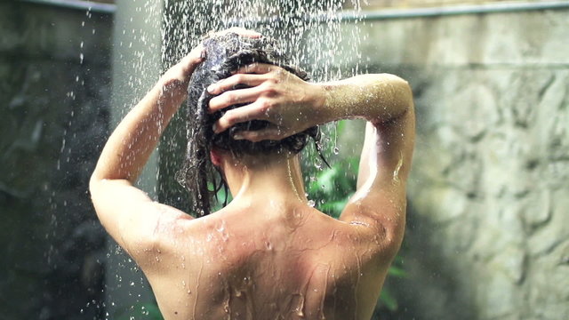 Young woman washing hair under shower, super slow motion, shot at 240fps
