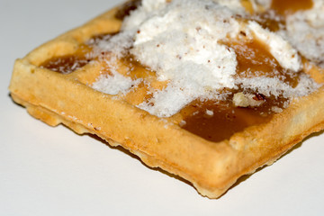 Waffles topped with cream and grounded biscuits