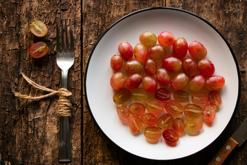 fork and sliced grapes on a white plate