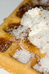 Waffles topped with cream and grounded biscuits