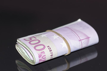A stack of euro banknotes with a rubber band.