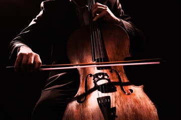 Man playing on cello on dark background
