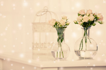 Beautiful flowers in vases on curtains background