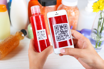 Woman scanning voucher code with mobile phone close up