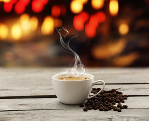 Cup of coffee on table on bright background