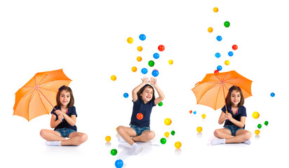 Girl holding an umbrella while raining colored balls
