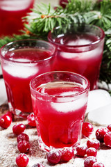 Christmas cranberry cocktail with ice, decorated with fir branch