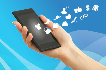 Hand holding smartphone with market icons