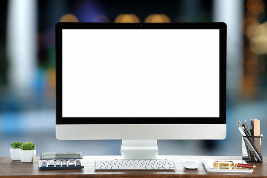 Computer on wooden table on abstract background