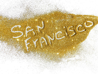Blurry inscription San Francisco on golden glitter sparkles on white background
