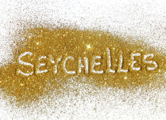 Inscription Seychelles on golden glitter sparkle on white background
