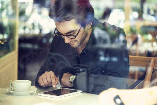 Young man using digital tablet in cafe