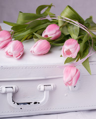 Pink tulips, white vintage suitcases.