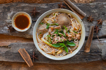 Pho Vietnamese beef soup on a wooden background