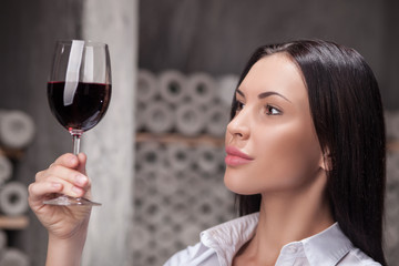 Close-up cute female sommelier is choosing perfect drink