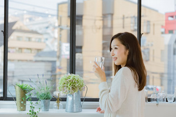 水を飲むパジャマ姿の女性
