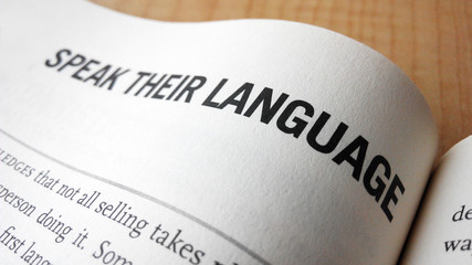 Speak their language word on a book