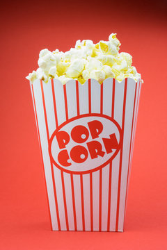 Classic box cinema popcorn on red background.