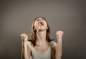 Portrait of young woman winner gesture. Winning success woman happy ecstatic celebrating being a winner. 