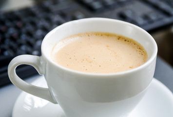 Coffee cappuccino, keyboard and mouse on the table