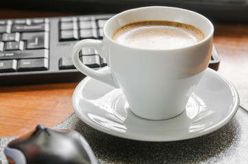 Coffee cappuccino, keyboard and mouse on the table
