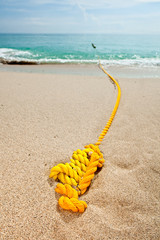 Yellow rope on the sandy beach - 93736657