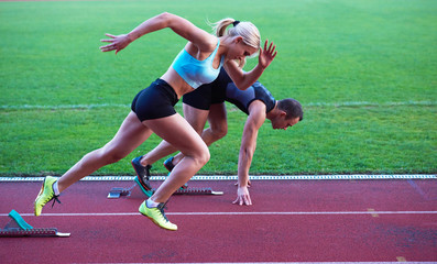woman group  running on athletics race track from start