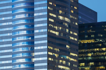 windows of office buildings illuminated at night for background